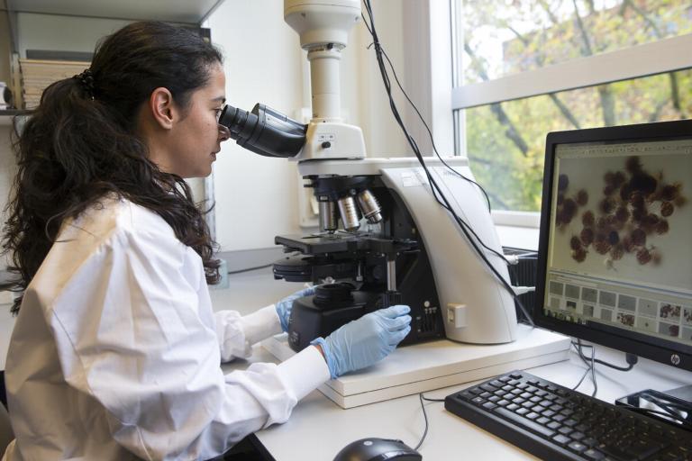 Vrouw achter microscoop